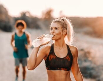 A picture of someone drinking water to stay hydrated after working out