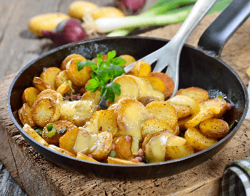 A picture of fried potatoes in a frying pan
