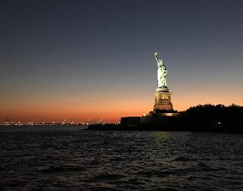 A picture of the Statue of Liberty as the sun sets