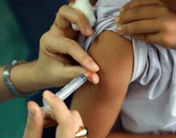 A vaccine being administered via an injection