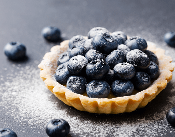 A picture of a tartlet pie that contains blueberries