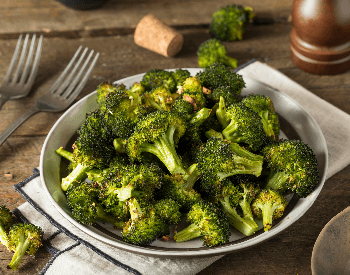 A picture of a bowl that contains roasted broccoli