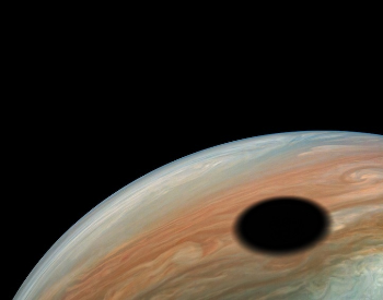 A photo of Io's shadow casted on Jupiter.