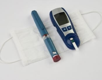 A picture of a diabetes blood sugar testing device and insulin injector