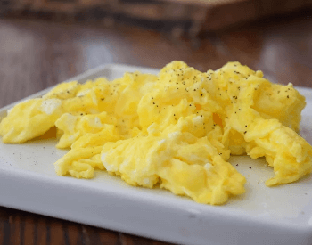 A picture of scrambled eggs, a food with a good source of protein